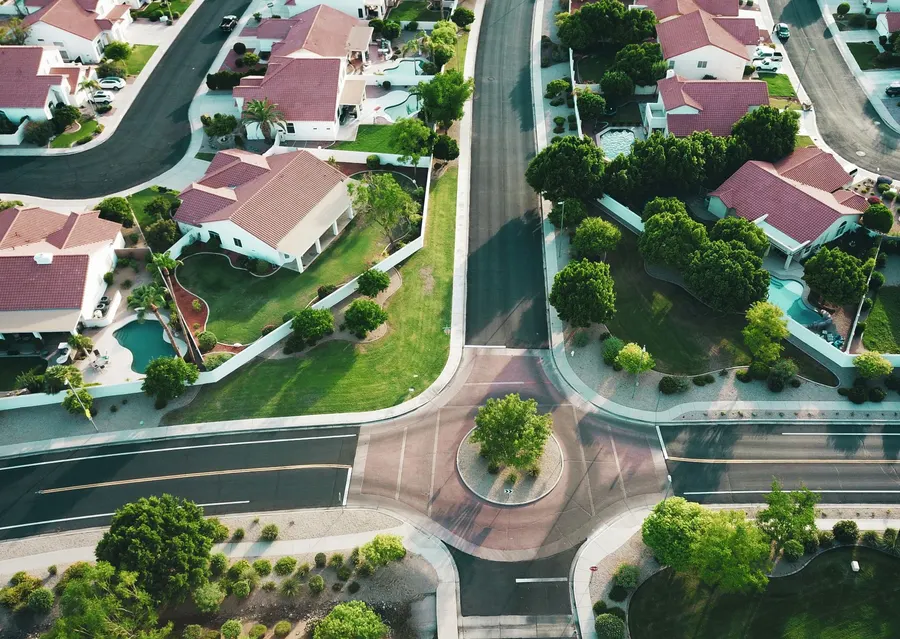 Vista aérea de um bairro residencial com casas e ruas arborizadas